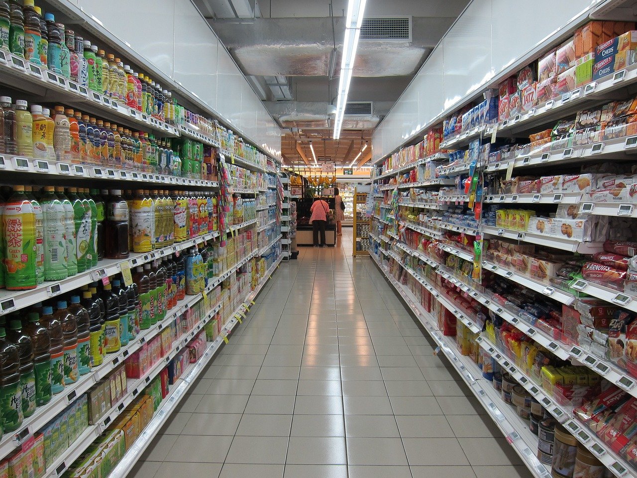 Ultra-verarbeitete Lebensmittel können Lebenszeit beeinflussen Ein Gang im Supermarkt mit Convenience Produkten in den Regalen auf beiden Seiten