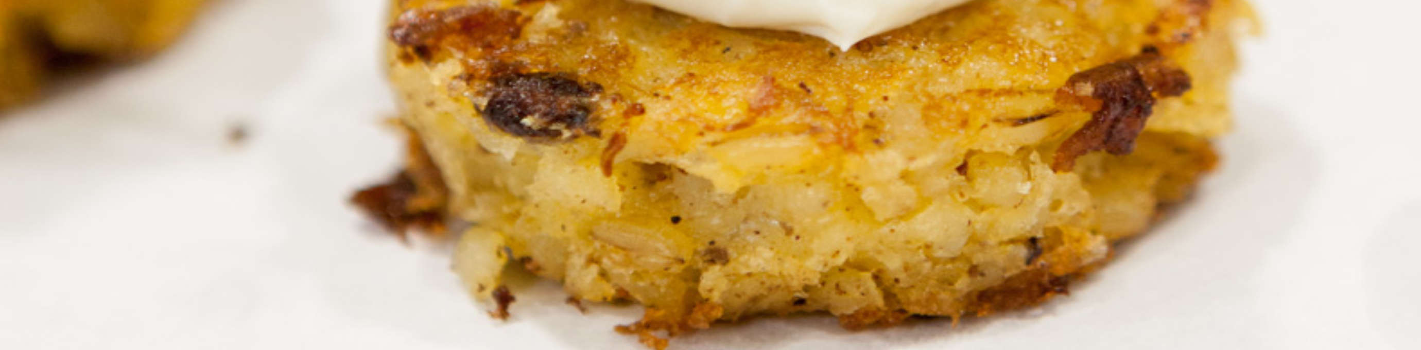 Kartoffeltaler aus Gerstoni Gourmet Gerste mit einem Klecks weißer Paste und Dill, außerdem ein Lachswürfel als Topping aufliegend