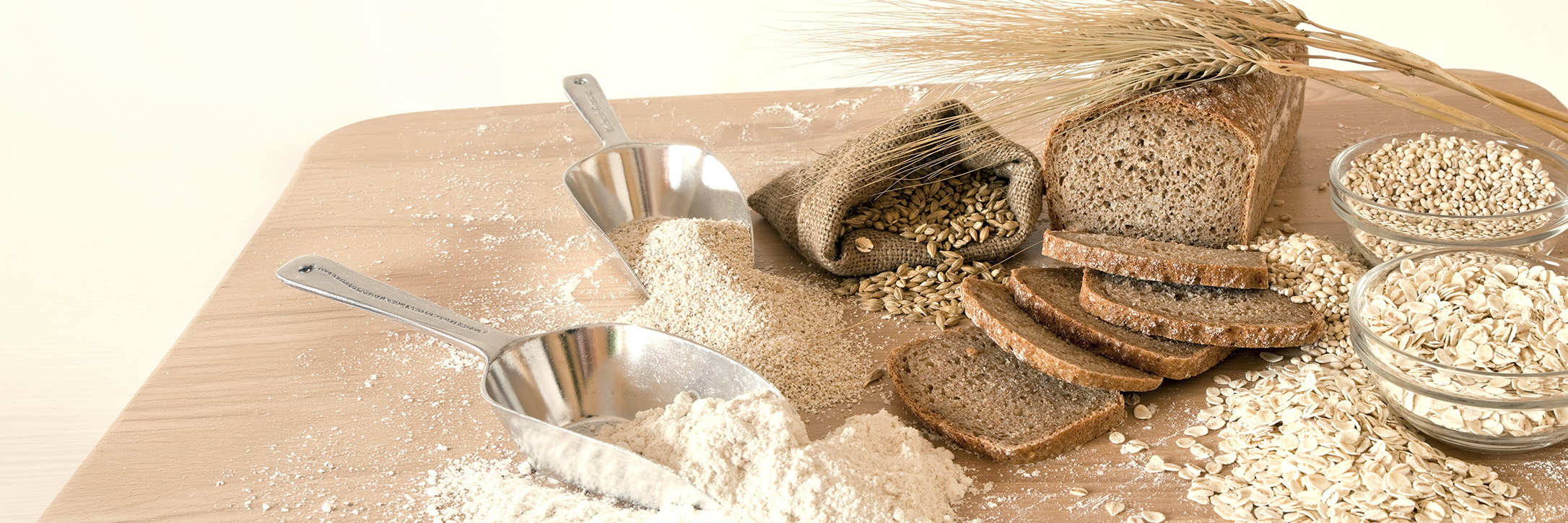 Leckeres Gerstenbrot mit Gerstenmehl, als auch Gerstenträucher auf einem Tisch