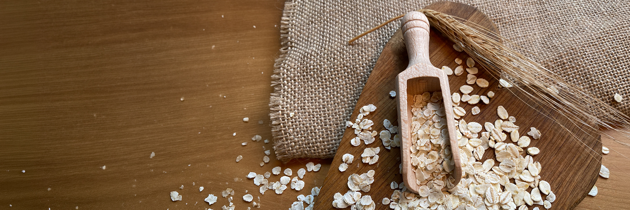 Natürliche Gerstenflocken auf einem Holzbrett